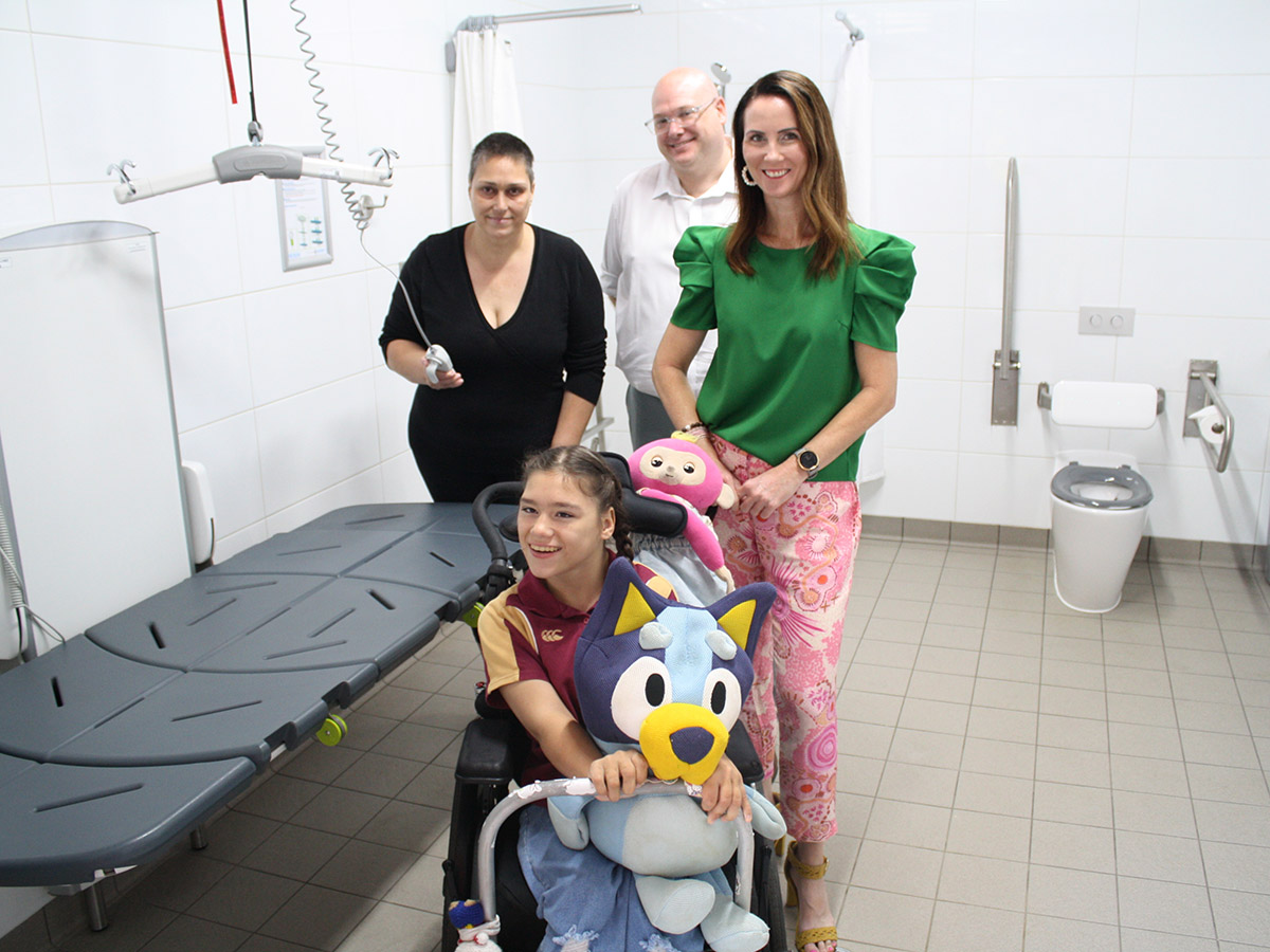 Rights In Action disability advocate Doreen Deede and her daughter, Emma, with Cairns Mayor Amy Eden and ARC Disability CEO Benjamin Keast, inside the new Changing Places accessible adult change facility at the Esplanade Lagoon.